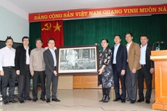 Ông Lê Quốc Minh, Phó Tổng Giám đốc Thông tấn xã Việt Nam trao quà lưu niệm cho Ủy ban nhân dân huyện Kim Môn, ngày 12/1. (Ảnh: Hạnh Nguyễn/Vietnam+)