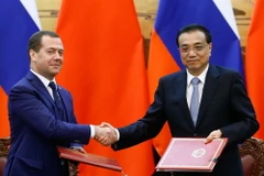 Thủ tướng Trung Quốc Lý Khắc Cường (phải) và Thủ tướng Nga Dmitry Medvedev (trái) tại lễ ký các thỏa thuận hợp tác song phương ở Bắc Kinh, Trung Quốc ngày 7/11/018. (Ảnh: AFP/TTXVN)