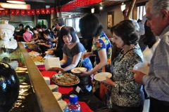 Quan khách nhiệt tình thưởng thức các món ăn Việt Nam. (Ảnh: Đình Lượng/TTXVN)