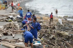 Người dân dọn dẹp đống đổ nát do bão Yutu tại Manila, Philippines ngày 30/10/2018. (Ảnh: AFP/TTXVN)