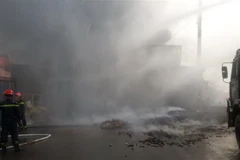 Cảnh sát phòng cháy chữa cháy cùng người dân đang tích cực dập lửa. (Ảnh: Lê Xuân/TTXVN)