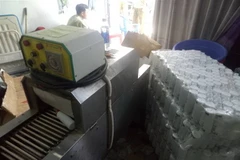 Máy móc sản xuất mỹ phẩm giả và tang vật bị thu giữ. (Ảnh: Mạnh Linh/TTXVN)