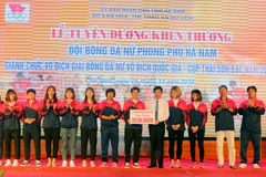 Ông Bùi Quang Cẩm, Phó chủ tịch UBND tỉnh Hà Nam trao giấy khen và số tiền thưởng 200 triệu đồng từ quỹ khen thưởng Ủy ban Nhân dân tỉnh Hà Nam cho đội bóng Phong Phú Hà Nam. (Ảnh: Đại Nghĩa/TTXVN)