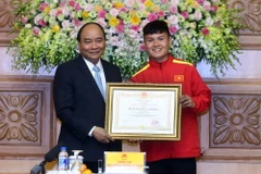 Thủ tướng Nguyễn Xuân Phúc trao tặng Huân chương lao động Hạng Nhì cho cầu thủ Nguyễn Quang Hải. (Ảnh: Thống Nhất/TTXVN)