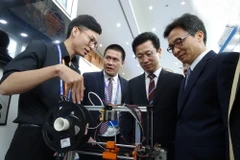 Phó Thủ tướng Vũ Đức Đam và Chủ tịch Hiệp hội WTA, ngài Her Tae Jeong xem các sản phẩm công nghệ tại hội chợ. (Ảnh: Nguyễn Huyền Trang/TTXVN)