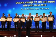 Ông Nguyễn Thiện Nhân, Ủy viên Bộ Chính trị, Bí thư Thành ủy Thành phố Hồ Chí Minh và ông Nguyễn Thành Phong, Chủ tịch Ủy ban Nhân dân Thành phố Hồ Chí Minh chúc mừng các doanh nghiệp tiêu biểu. (Ảnh: Xuân Anh/TTXVN)