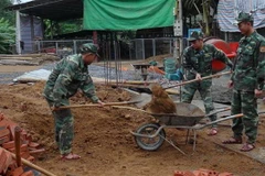 Các chiến sỹ Đồn Biên phòng Mường Cai giúp đồng bào vùng biên xây nhà. (Ảnh: Hữu Quyết/TTXVN)
