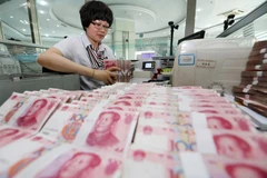 Kiểm tiền nhân dân tệ tại ngân hàng ở Liên Vận Cảng, tỉnh Giang Tô, Trung Quốc. (Nguồn: THX/TTXVN)