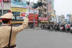 Cảnh sát giao thông làm nhiệm vụ phân luồng, hướng dẫn giao thông tại ngã năm Ô Chợ Dừa. (Ảnh: Doãn Tấn/TTXVN)