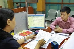 Hoạt động nghiệp vụ tại Bộ phận tiếp nhận, cung ứng các dịch vụ về thuế, Cục Thuế Hà Nội. (Ảnh: Hoàng Hùng/TTXVN)