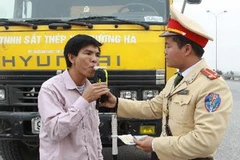 Kiểm tra nồng độ cồn trong khí thở của tài xế. (Ảnh: Doãn Tấn/TTXVN)