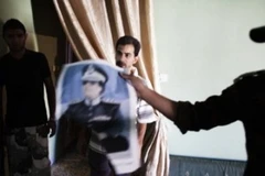 NTC tịch thu một bức ảnh của cựu lãnh đạo Libya Gaddafi trong căn hộ của một người bị nghi ngờ là phần tử trung thành bất ổn tại Abu Salim. (Ảnh: AFP)