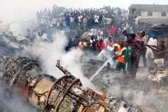 Lính cứu hỏa làm nhiệm vụ tại hiện trường vụ tai nạn máy bay. (Ảnh: THX/TTXVN)