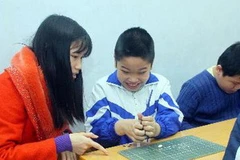 Chăm sóc trẻ khuyết tật. (Ảnh: TTXVN)