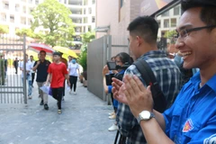 Nụ cười hạnh phúc của tình nguyện viên khi thấy các bạn thí sinh hoàn tất bài thi. (Ảnh: PV/Vietnam+) 