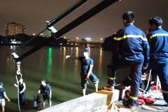 Cảnh sát tiến hành tìm kiếm và trục vớt chiếc xe (Ảnh: CTV T.Long/Vietnam+) 