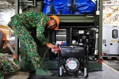 Bộ đội vận hành máy móc tẩy độc trong kho Rạng Đông. (Ảnh: Sơn Bách/Vietnam+) 