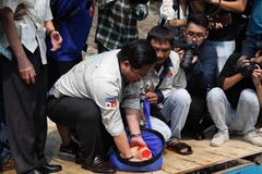 Chuẩn bị thả cá xuống sông Tô Lịch. (Ảnh: Sơn Bách/Vietnam+) 