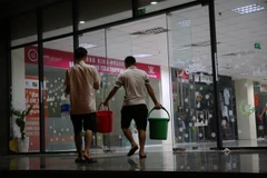 Xách nước như thời... bao cấp tại khu đô thị Nam An Khánh, Hà Nội đêm 15/10. (Ảnh: Minh Sơn/Vietnam+) 