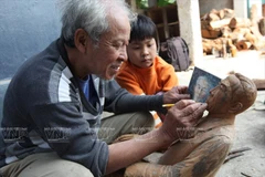 Quá trình làm tượng truyền thần thu hút sự chú ý của các em nhỏ.