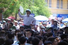 Tâm trạng lo lắng giữa cái nóng khiến sự chờ đợi của các bậc phụ huynh trong lúc con thi khiến thời gian như dài thêm.