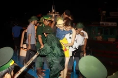 Khách mắc kẹt được tàu HQ634 vùng 1 Hải Quân bàn giao cho 3 tàu du lịch tại khu vực Cửa Đối để chở về đất liền. (Ảnh: Minh Quyết/TTXVN)