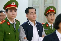 Cảnh sát dẫn giải bị cáo Phan Văn Anh Vũ. (Ảnh: Doãn Tấn/TTXVN)
