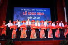 Lãnh đạo tỉnh Long An cùng các đại biểu cắt băng khai mạc triển lãm ảnh. (Ảnh: Bùi Giang/TTXVN)