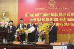 Lãnh đạo tỉnh Hà Nam tặng hoa chúc mừng 2 chủ đầu tư dự án. (Ảnh: Nguyễn Chinh/TTXVN)