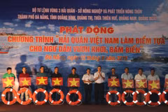 Lãnh đạo Quân chủng Hải quân và Bộ Tư lệnh Vùng 3 Hải quân tặng cờ Tổ quốc, phao cứu sinh cho ngư dân tại chương trình. (Ảnh: Nguyễn Sơn/TTXVN)
