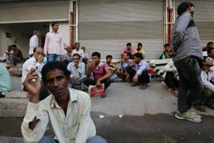 Người dân chờ được thuê làm ngồi bên vệ đường ở Mumbai của Ấn Độ. (Nguồn: Reuters)