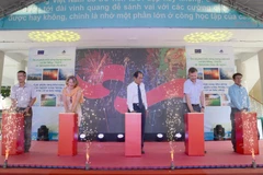 Các đại biểu nhấn nút khai trương hệ thống điện năng lượng Mặt Trời. (Ảnh: Văn Dũng/TTXVN)