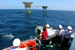 Các cán bộ chiến sĩ Vùng 2 Hải quân cùng các nhà báo, phóng viên trên tàu Trường Sa 19 vẫy chào cán bộ chiến sĩ trên Nhà giàn Dk1/15 (Phúc Nguyên). (Ảnh minh họa: Thành Đạt/TTXVN)