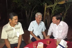 Bí thư Tỉnh ủy Vĩnh Long Trần Văn Rón (bên phải) chia buồn, động viên gia đình nạn nhân tử vong trong vụ tai nạn. (Ảnh: Lê Thúy Hằng/TTXVN)