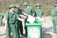 Bộ đội biên phòng tham gia dọn rác tại bãi biển. (Ảnh minh họa: Huỳnh Phúc Hậu/TTXVN)