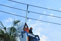 Công nhân Công ty điện lực lắp đặt thiết bị SRFI trên lưới điện trung áp. (Ảnh: Tiên Minh/TTXVN)