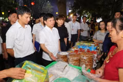 Ông Ngô Văn Quý, Phó Chủ tịch Ủy ban Nhân dân thành phố Hà Nội cùng các đại biểu tham quân các gian hàng ẩm thực. (Ảnh: Thành Đạt/TTXVN)