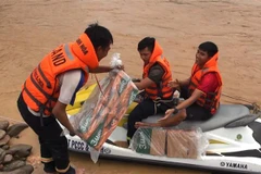 Lực lượng chức năng vượt sông mang nhu yếu phẩm vào với đồng bào bản Sa Ná, xã Na Mèo, huyện Quan Sơn, tỉnh Thanh Hóa. (Ảnh: Trịnh Duy Hưng/TTXVN)