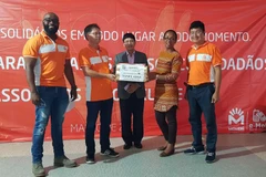 Đại sứ Việt Nam tại Mozambique Lê Huy Hoàng, Phó Tổng Giám đốc Movitel Nguyễn Ngọc Nam và Giám đốc Sở Công Thương tỉnh Sofala Josefa Sing Sang tại buổi lễ bàn giao lô hàng cứu trợ. (Ảnh: Phi Hùng/TTXVN)