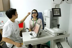 Các bác sỹ Bệnh viện Mắt Hà Nội 2 khám, tư vấn cho người bệnh. (Ảnh: Dương Ngọc/TTXVN)