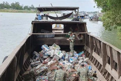 Cán bộ chiến sỹ Đồn Biên phòng Cửa khẩu Long Bình kiểm đếm số phế liệu vừa thu giữ. (Ảnh: Công Mạo/TTXVN)