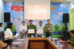 Đại diện cơ quan chức năng tặng bằng khen cho các cá nhân. (Ảnh: Đậu Tất Thành/TTXVN)