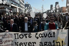 Những người tham gia lễ tưởng niệm đã mang theo những quả bóng màu trắng mang dòng chữ Never Again. (Nguồn: AFP)