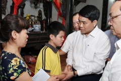 Chủ tịch UBND thành phố Hà Nội Nguyễn Đức Chung thăm hỏi, động viên gia đình chị Lê Thị Thu Hà. (Ảnh: Lâm Khánh/TTXVN)