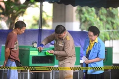 Đại diện cử tri, chính quyền và Ủy ban Bầu cử cùng kiểm tra thùng phiếu trước khi bắt đầu bỏ phiếu. (Ảnh: Sơn Nam/TTXVN)