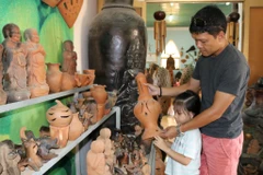 Du khách lựa chọn sản phẩm gốm Bàu Trúc. (Ảnh: Nguyễn Thành/TTXVN)