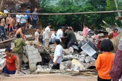 Người dân đào bới đống đổ nát của căn nhà bị sập, cứu 3 thành viên trong gia đình anh Nông Văn Trường. (Ảnh: CTV/TTXVN)