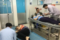 Công nhân nghi bị ngộ độc thực phẩm được cấp cứu tại Bệnh viện quận Tân Phú. (Ảnh: Đinh Hằng/TTXVN)