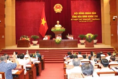 Các đại biểu HĐND tỉnh Hòa Bình thông qua các nghị quyết quan trọng của phiên họp bất thường. (Ảnh: Nhan Sinh/TTXVN)