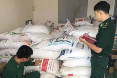 Cán bộ, chiến sỹ Đồn Biên phòng cửa khẩu quốc tế Vĩnh Xương kiểm đếm số tang vật vừa thu giữ được. (Ảnh: Công Mạo/TTXVN)